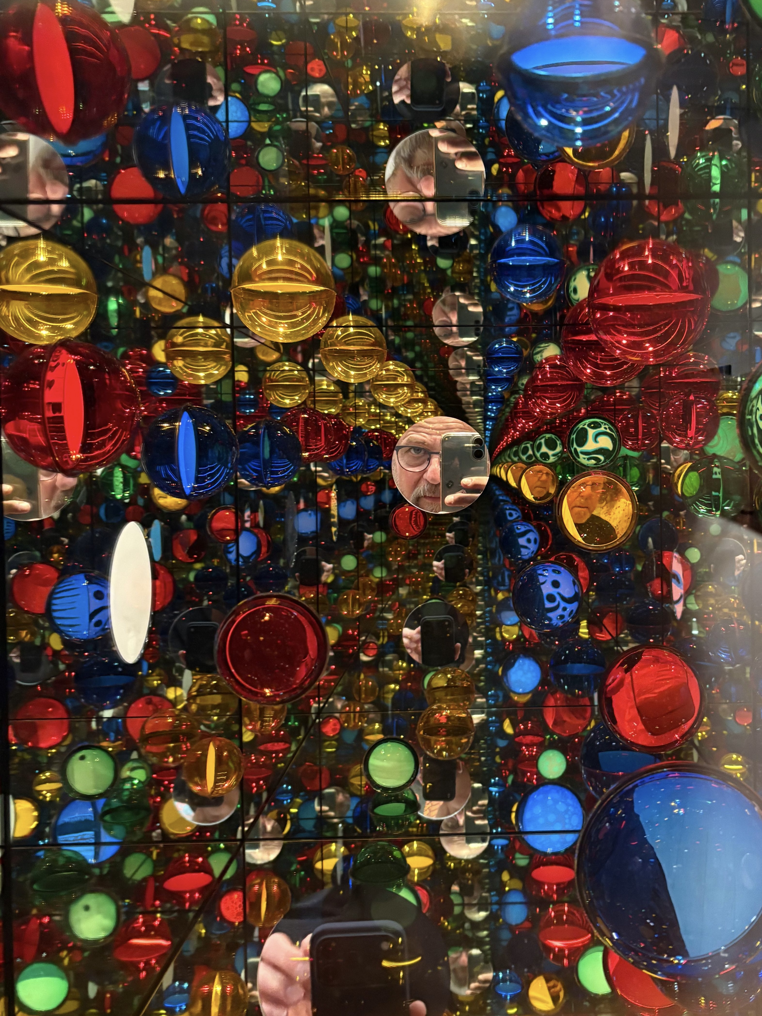 Leuchtende bunte Formen und vielfache Spiegelungen in der Yayoi-Kusama-Ausstellung.